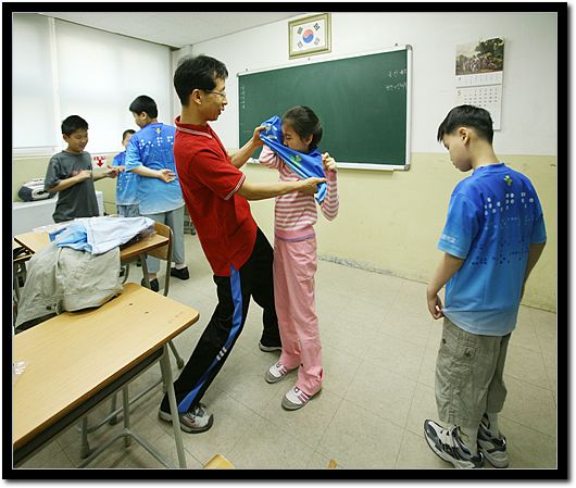 선물 받은 옷을 담임선생님과 입어보고 있다. 